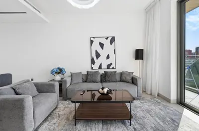a living room with a couch and a table at Sobha Hartland, Green building2 1BR in Dubai