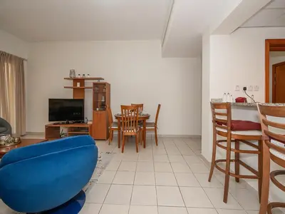 a living room with a blue couch and a table at Bright & Spacious 2BR Apartment | The Greens Community in Dubai