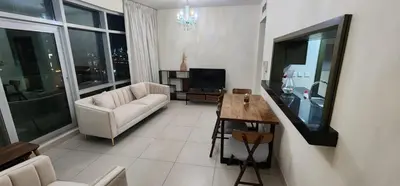 a living room with a couch and a table at Lofts West Tower - Downtown by Golden Casa in Dubai