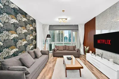 a living room with a couch and a tv at Lux 1BR & Steps to Dubai Mall & Burj Khalifa in Dubai