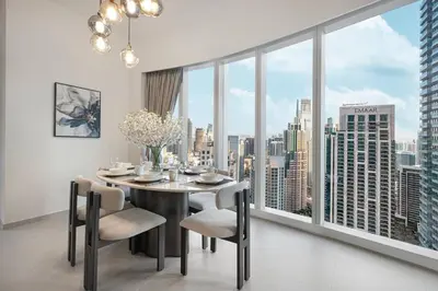 a dining room with a table and chairs and a large window at Luxury 4BR Burj View Steps from Dubai Mall in Dubai
