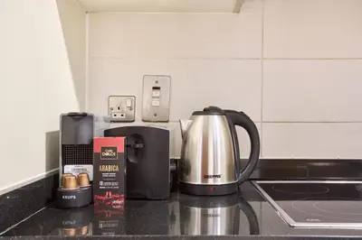 a kitchen counter with a coffee maker and a coffeemaker at Palm Jumeirah Oasis - Stylish 1 Bedroom Apartment with Garden, Pool & private Beach Access in Dubai