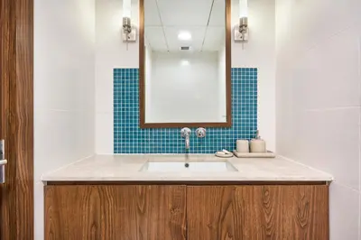 a bathroom with a sink and a mirror at Palm Jumeirah Oasis - Stylish 1 Bedroom Apartment with Garden, Pool & private Beach Access in Dubai