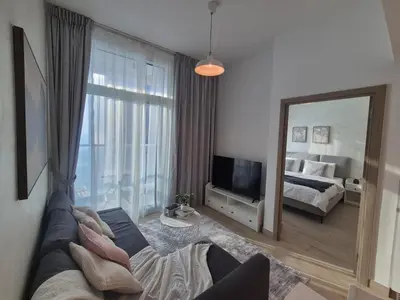 a living room with a couch and a mirror at Modern one bedroom in marina in Dubai