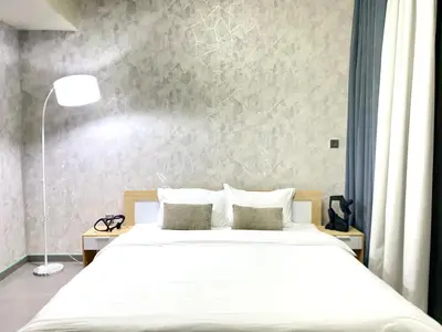 a bedroom with a white bed and a wall at Bright & Cozy 1BR in Business Bay with Skyline Views in Dubai