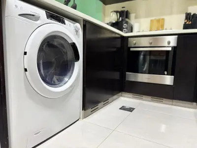 a white washer and dryer in a kitchen at Bright & Cozy 1BR in Business Bay with Skyline Views in Dubai