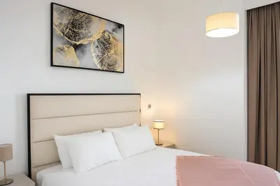 a bedroom with a white bed and a picture on the wall at Luxury 1BR with Marina Views Swimming Pool Gym in Dubai