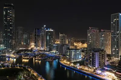 a city skyline at night with a river and buildings at Luxury 1BR with Marina Views Swimming Pool Gym in Dubai