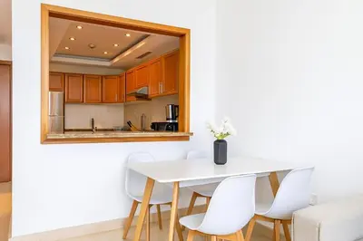 a kitchen with a white table and white chairs at Luxury 1BR with Marina Views Swimming Pool Gym in Dubai