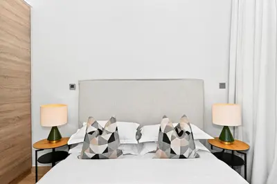 a bedroom with a white bed with two lamps at Dubai Marina Living 1BR near JBR in Dubai