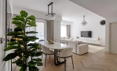 a white living room with a table and a plant at Amazing 2 bedroom with Sea view ! Rimal ! in Dubai