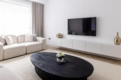 a white living room with a black coffee table at Amazing 2 bedroom with Sea view ! Rimal ! in Dubai