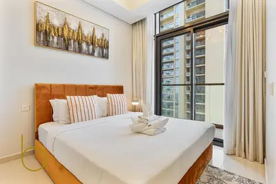 a bedroom with a large bed with a large window at Bookable 2 bed Damac Aykon City with Balcony & Pool access in Dubai