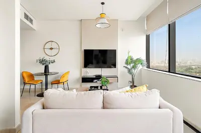a living room with a white couch and a large window at Silkhaus Comfy Studio in Sky Gardens with DIFC Views in Dubai