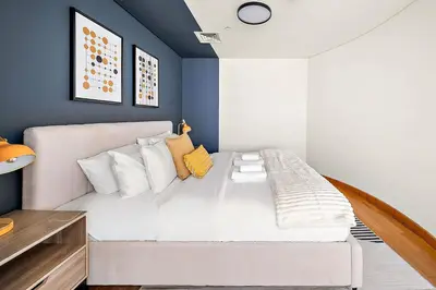 a bedroom with a white bed and blue walls at Silkhaus Comfy Studio in Sky Gardens with DIFC Views in Dubai