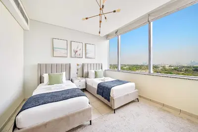 two beds in a room with a large window at Silkhaus Lavish 2BDR at Sky Gardens in DIFC in Dubai