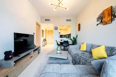 a living room with a couch and a flat screen tv at TRPS - Binghatti Jasmine, JVC - Pool View, Fully Furnished, Prime JVC Location in Dubai