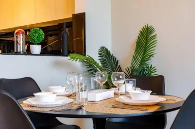 a dining room table with plates and wine glasses at TRPS - Binghatti Jasmine, JVC - Pool View, Fully Furnished, Prime JVC Location in Dubai