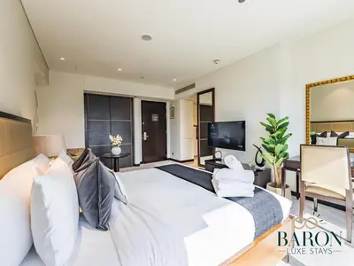a bedroom with a large white bed and a flat screen tv at The Muse in Dubai