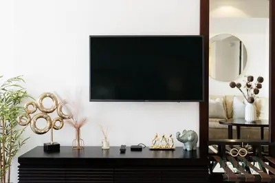 a living room with a tv on a wall at The sleek in Dubai