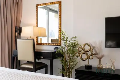 a bedroom with a desk and a mirror and a bed at The sleek in Dubai