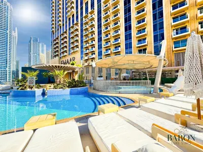 a swimming pool with lounge chairs and a large building at The sleek in Dubai