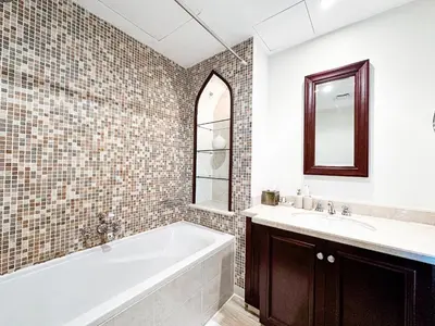 a bathroom with a tub and a sink and a mirror at Royal Escape Burj Khalifa View 2BR in Downtown Dubai in Dubai