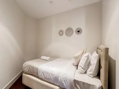 a white bedroom with a bed with white sheets and pillows at Royal Escape Burj Khalifa View 2BR in Downtown Dubai in Dubai