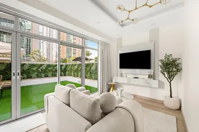 a living room with a couch and a tv at FIRST CLASS 2BR Luxury Facing Burj Khalifa in Dubai