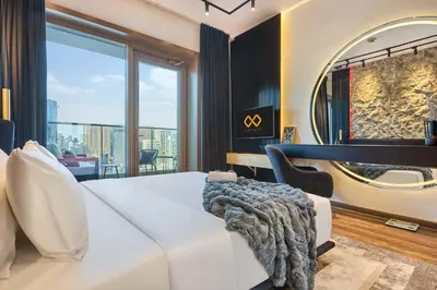 a bedroom with a white couch and a large window at Stylish 1BR Apartment with Marina View, Balcony, Pool & Gym Access in Dubai