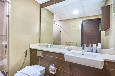 a bathroom with a sink and a toilet and a mirror at Stylish 1BR Apartment with Marina View, Balcony, Pool & Gym Access in Dubai