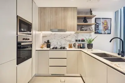 a kitchen with white cabinets and a sink at Stylish 1BR Apartment with Pool, Gym & Balcony - JVC Oxford Terraces in Dubai