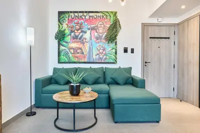 a living room with a blue couch and a table at Stylish 1BR Apartment with Pool, Gym & Balcony - JVC Oxford Terraces in Dubai