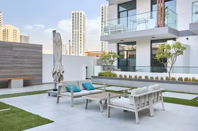 a rooftop patio with furniture and a building at Stylish 1BR Apartment with Pool, Gym & Balcony - JVC Oxford Terraces in Dubai