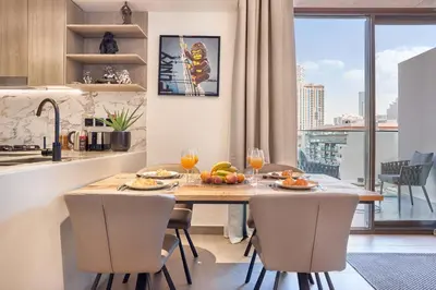 a kitchen with a table with food and wine glasses at Stylish 1BR Apartment with Pool, Gym & Balcony - JVC Oxford Terraces in Dubai