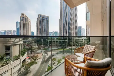 a balcony with two chairs and a view of a city at Act One Act Two Stylish 1BR Near Burj Khalifa & Fountains in Dubai