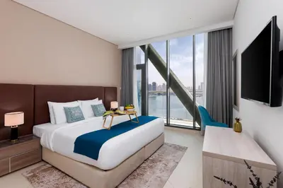 a bedroom with a large bed and a large window at Maison Privee - Elegant Palm Retreat with Iconic Sea & Marina Vws in Dubai