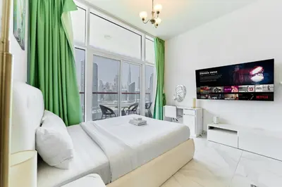 a bedroom with a bed with a large window at Modern Studio With Iconic Burj Khalifa & Canal Views in Dubai