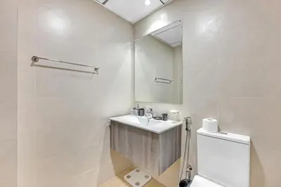 a white bathroom with a sink and a mirror at Classy Studio At Rukan in Dubai