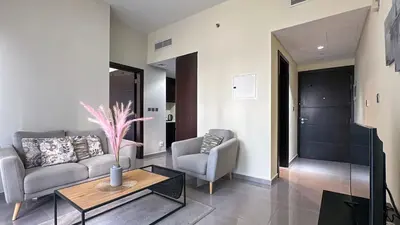a living room with a couch and two chairs and a table at Modern 1BR in Merano, Near Downtown & Burj Khalifa - 14AB07 in Dubai