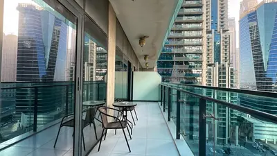 a balcony with tables and chairs on a building at Modern 1BR in Merano, Near Downtown & Burj Khalifa - 14AB07 in Dubai