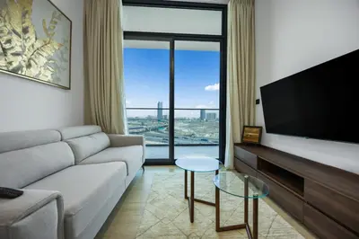 a living room with a couch and a flat screen tv at Modern 1BR in Binghatti Luna, JVC District in Dubai