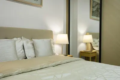 a bedroom with a bed with two lamps and a mirror at Modern 1BR in Binghatti Luna, JVC District in Dubai