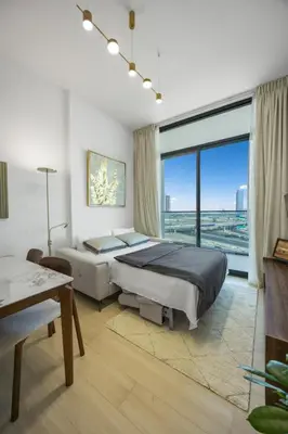 a bedroom with a large bed and a large window at Modern 1BR in Binghatti Luna, JVC District in Dubai