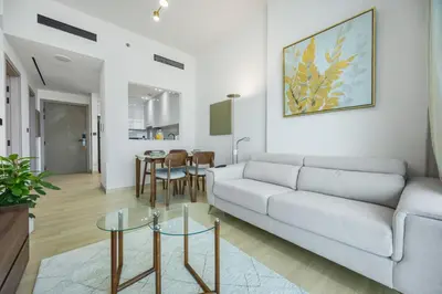 a living room with a couch and a table at Modern 1BR in Binghatti Luna, JVC District in Dubai