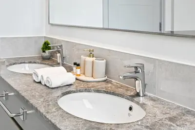 a bathroom counter with two sinks and a mirror at Burj Khalifa View Next to Dubai Mall Sleeps 12 in Dubai