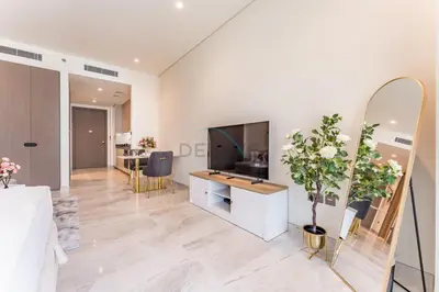 a living room with a television and a dining room at Furnished Studio with Burj Khalifa View, Near Dubai Water Canal, with Easy Access to Downtown, Peninsula Five - 3, Business Bay by Deluxe Holiday Homes in Dubai