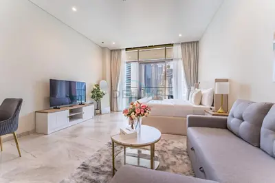 a living room with a couch and a bed at Furnished Studio with Burj Khalifa View, Near Dubai Water Canal, with Easy Access to Downtown, Peninsula Five - 3, Business Bay by Deluxe Holiday Homes in Dubai