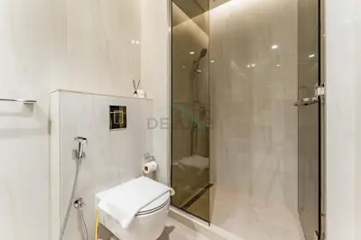 a white bathroom with a shower and a toilet at Furnished Studio with Burj Khalifa View, Near Dubai Water Canal, with Easy Access to Downtown, Peninsula Five - 3, Business Bay by Deluxe Holiday Homes in Dubai