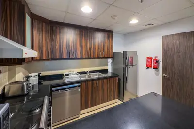a kitchen with wooden cabinets and a stainless steel refrigerator at 2 Bedroom Apts in JBR Shams 1 by Luxaura in Dubai